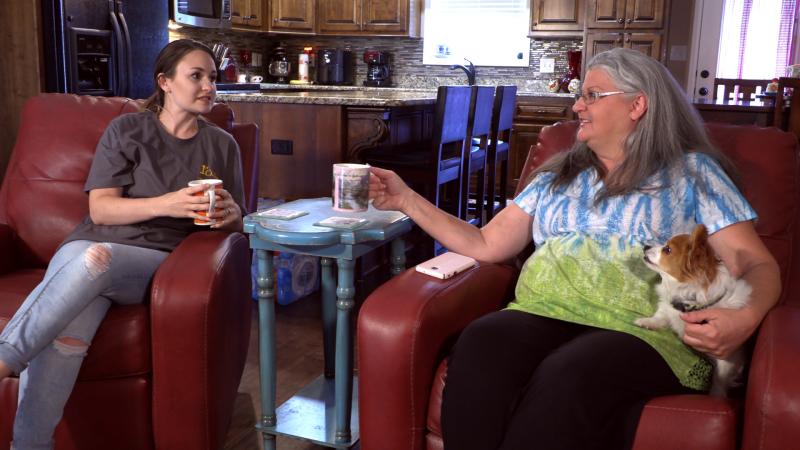 Elderly woman taking the hand of a caretaker 